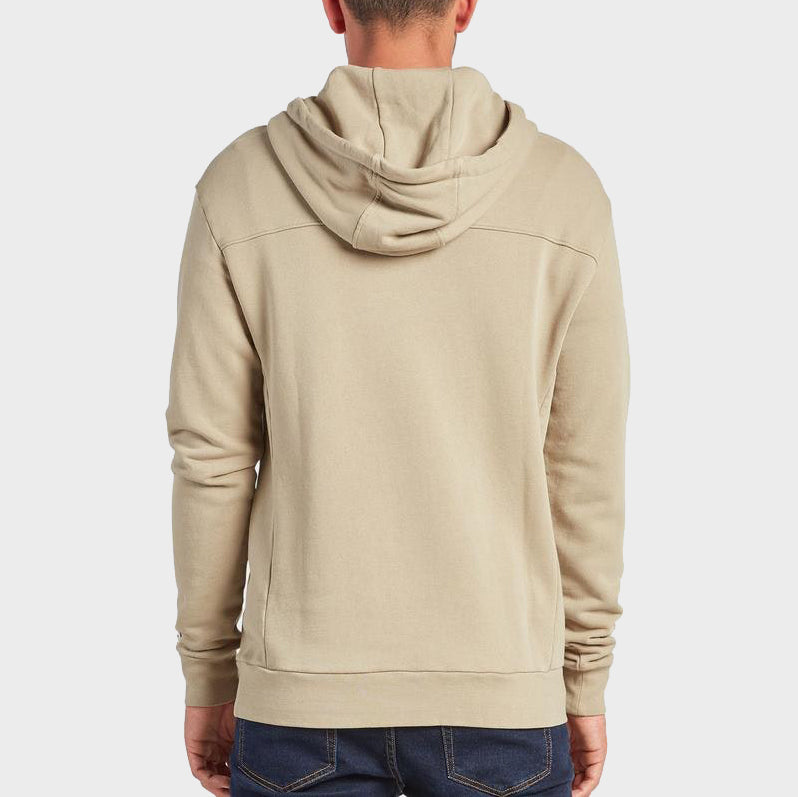 A person wearing a comfortable beige Academy Brand Boston Hoodie and dark blue jeans is shown from the back, standing against a plain white background.