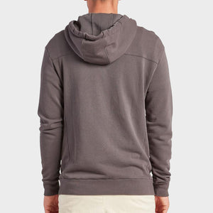 A person is shown from the back wearing the Academy Brand Boston Hoodie in gray with the hood down, paired with light-colored pants, standing against a plain light background.