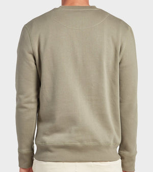 A person is seen from the back wearing the Academy Brand College Crew in olive green with light-colored pants, standing against a plain, light background. The relaxed long-sleeve sweatshirt captures Academy Brand's effortless style.