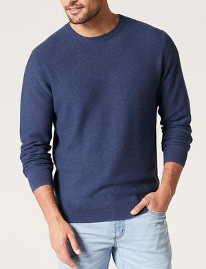 A man wears the Blazer Mason Cotton Textured Crew Neck in navy blue with light blue jeans, standing against a plain light background. One hand is in his pocket and the other at his side; his face is partially out of frame.