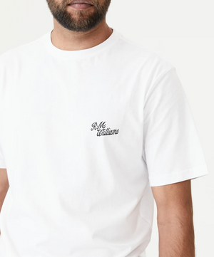 A person with a short beard is wearing an RM Williams Longhorn Byron Tee, crafted from premium cotton jersey. The unisex style features a small embroidered logo on the left chest area, all set against a plain white background.