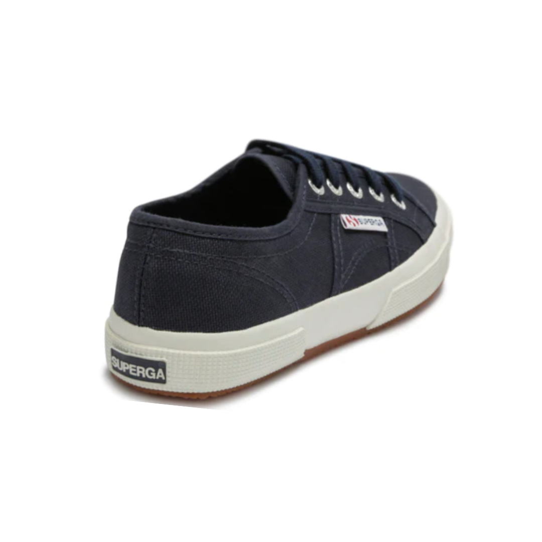 The Superga Cotu Classic Sneaker is navy blue with a white sole, featuring "SUPERGA" on the heel and side. It highlights a classic canvas upper design with six eyelets for laces.