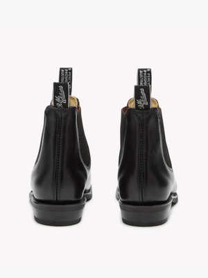 A pair of black RM Williams Adelaide Rubber Sole Boots shown from the back. The boots have pull tabs with white text, sturdy soles, and sleek stitching along the sides. Made from Yearling leather, these classic boots stand out beautifully against the plain white background.