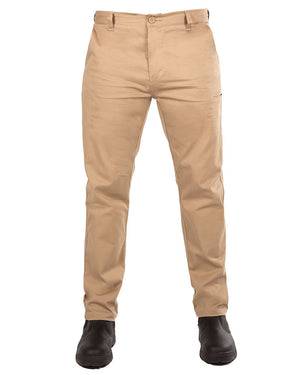 A person wearing the UNIT Ignition Stretch Pant in beige khaki. The durable work pants feature a straight-leg design and are paired with black boots. The pants have a button and zip closure, belt loops, and side pockets against a plain white background.