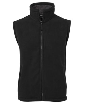 The JBs Shepherd Vest is a sleeveless, black micro fleece vest featuring a full-length zipper down the front. It has an upright collar, and the material appears soft and warm. The vest includes two side pockets and boasts a simple, functional design.