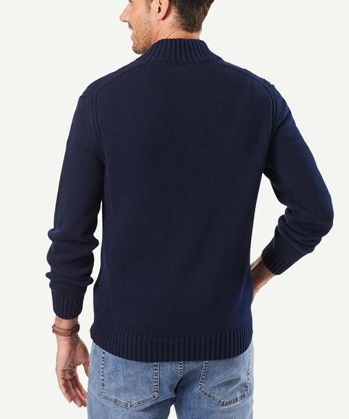 A person facing away wears a navy blue Gazman Chunky Button Neck Knit with a high collar and light blue jeans. The cotton sweater in regular fit has ribbed cuffs and hem against a plain, light background.