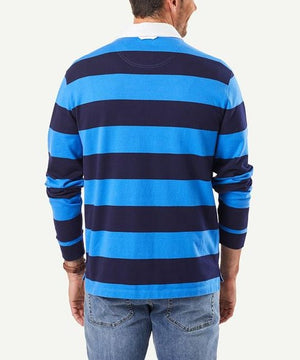 A person seen from behind is wearing a regular fit, long-sleeved Gazman Block Stripe Rugby with wide blue and navy horizontal stripes. They have short hair and are also sporting light blue jeans.