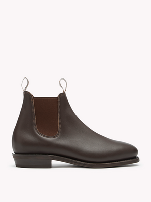 The RM Williams Adelaide Rubber Sole Boot in dark brown leather features elastic side panels and pull tabs, highlighting its smart-casual style against a plain white background.