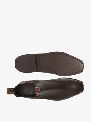 A pair of RM Williams Comfort Craftsman Boots is displayed, one shown from the top and the other from the bottom. The label on the inside reads "RM Williams." The sole is dark brown with the brand's logo embossed. Made from premium yearling leather, these handcrafted boots also feature a comfort innersole for added ease.