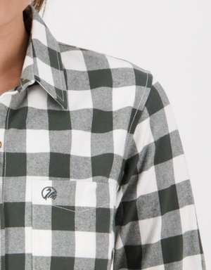 Close-up of a person wearing the Swanndri Womens Taranaki Tailor Shirt, a stylish black and white plaid 100% cotton button-up with front pocket, shown against a plain light background. Only part of the face and upper torso is visible.
