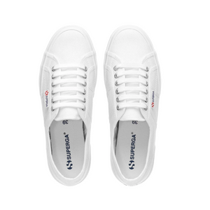 A pair of Superga Cotu Classic Sneakers in white with laces, viewed from above. The brand name in blue graces the side and canvas upper insole. These sneakers feature a classic, minimalist design.