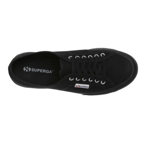 Aerial shot of the black Superga Cotu Classic Sneaker with laces, metal eyelets, a canvas upper featuring a small side Superga logo tag, and a hint of the rubber sole on the left.