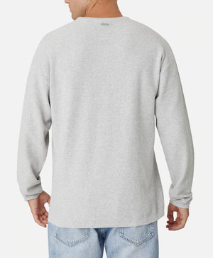 A person is shown from behind wearing an oversized fit, long-sleeve, light gray Industrie The Aries Knit and light blue jeans. The 100% cotton shirt has a subtle texture and a small brand logo at the upper center back. The background is plain white.