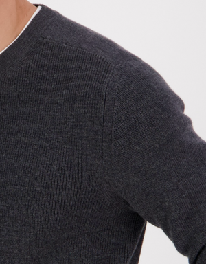 A close-up of a person wearing the Swanndri Otahu River Crew Neck Merino Knit in dark gray, showing just the shoulder, upper arm, and neck against a white background—ideal for referencing your half chest size.