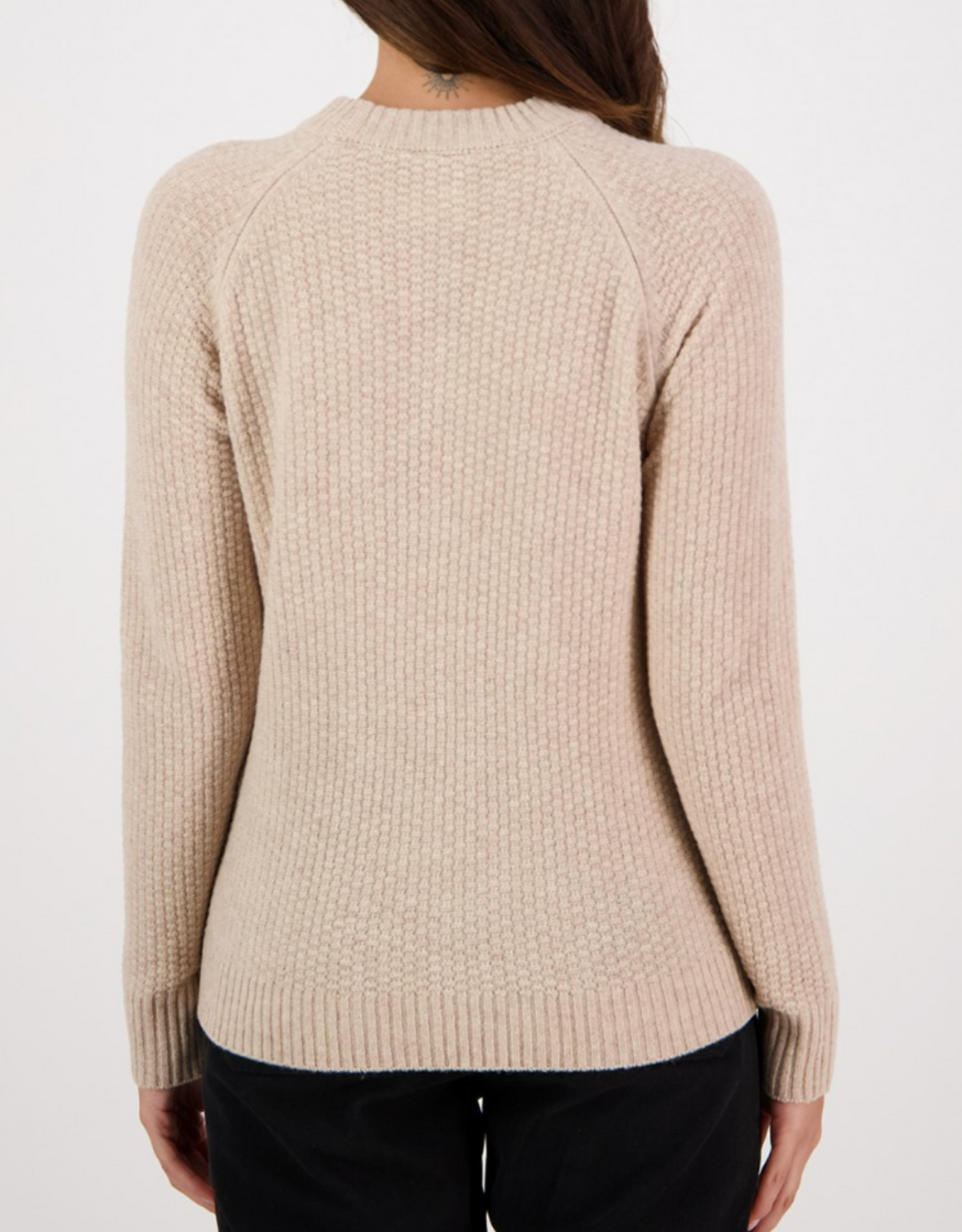 A person is wearing the Swanndri Hayes Park Waffle Knit Crew in beige, featuring long sleeves, a textured waffle design, and ribbed hem and cuffs. Their back faces the camera against a plain white backdrop, adding an understated elegance to the scene.