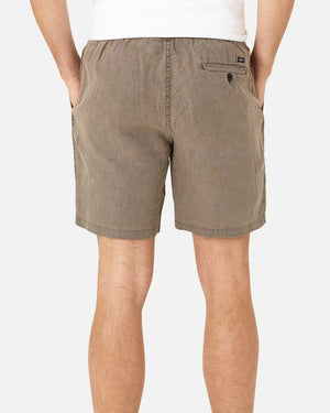 Someone is seen from the back wearing Industrie The Marina Linen Shorts. Made from 100% linen, these regular-fit light brown shorts offer ultimate comfort with an elastic waistband and a buttoned back pocket. Paired with a white top, it's a classic and relaxed look.
