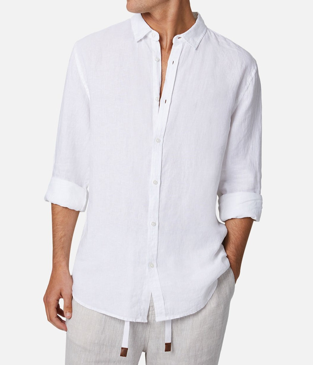 A person wears the Industrie The Tennyson Linen Shirt, a relaxed fit long-sleeve button-up made from 100% linen with rolled cuffs, perfectly matched with light-colored drawstring pants. The person's head is not in the image.
