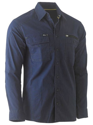 The Bisley Flex & Move Utility Work Shirt is a dark blue, long-sleeve button-up shirt with two chest pockets, one of which includes a zipper. It features a relaxed fit and stitching details along the seams and pockets. Additionally, it offers SPF 50+ protection for optimal safety in the sun.