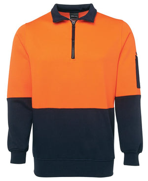 The JBs Hi Vis 1/2 Zip Fleecy is a high-performance workwear pullover designed in striking orange and black. This durable polyester cotton long-sleeve features a convenient zipper extending halfway down from the collar, with the top half in orange and bottom half and sleeves in black. Additionally, it includes a small pen pocket on the left sleeve for added functionality.