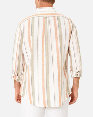 A man is seen from the back wearing the Industrie The Orchard Linen Shirt, a 100% linen, long-sleeve, button-up shirt featuring vertical stripes in pastel colors such as beige, peach, and olive green. The sleeves are rolled up to his elbows. He is also wearing white pants. The background is plain white.