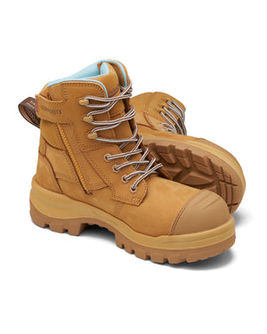 A pair of Blundstone RotoFlex Women's 8860 boots in tan features thick soles, white laces, and padded collars. One boot is upright, the other tilted to show the tread. Brown pull tabs with "Composite" text on the back add style and safety appeal.