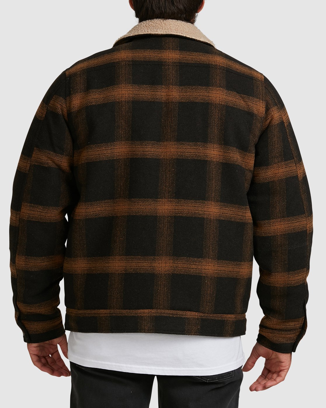 A person seen from behind wears the Billabong Barlow Sherpa Jacket, featuring black and brown plaid with a white sherpa collar. Their arms are relaxed by their sides, paired with a white shirt and black pants.