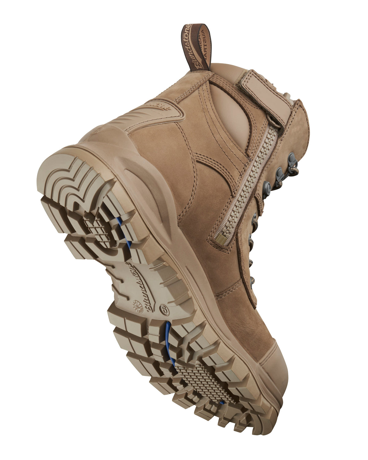 A close-up view of the Blundstone 984 Zip Sided Scuff Cap Safety Boot, showcasing its rugged, textured soles designed for traction and slip resistance. The tan work boot features metal eyelets and thick laces, a padded collar, a steel toe cap, and a pull tab at the back for easy wear. This well-constructed boot appears durable and built to last.