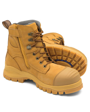 The Blundstone 992 Zip Sided Scuff Cap Safety Boot is a pair of tan-colored work boots featuring sturdy laces, metal eyelets, side zippers, steel toe caps, and thick, treaded rubber soles tailored for heavy-duty use. These water-resistant boots boast a rugged outdoor look with a soft inner lining for added comfort.