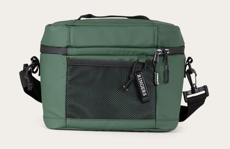 The Ringers Western Newport Soft Cooler Bag is a green camera bag featuring a black adjustable shoulder strap and carrying handle. It includes a zippered mesh pocket on the front and tags for branding. The main compartment is accessible via two zippers on the top, making this versatile bag also function as an insulated cooler. Its design is simple and structured.