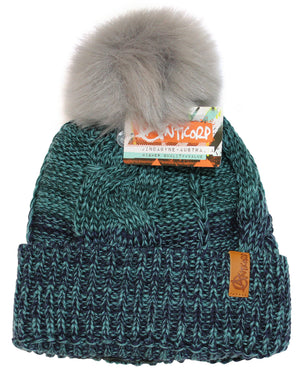 The Anticorp Ladies Freshies Beanie is a green and black knit hat with a large, fluffy gray pompom on top. It features a brown leather tag and an attached Anticorp label with information. Designed with a textured, braided pattern, it also includes a cozy fleece lining for extra warmth.