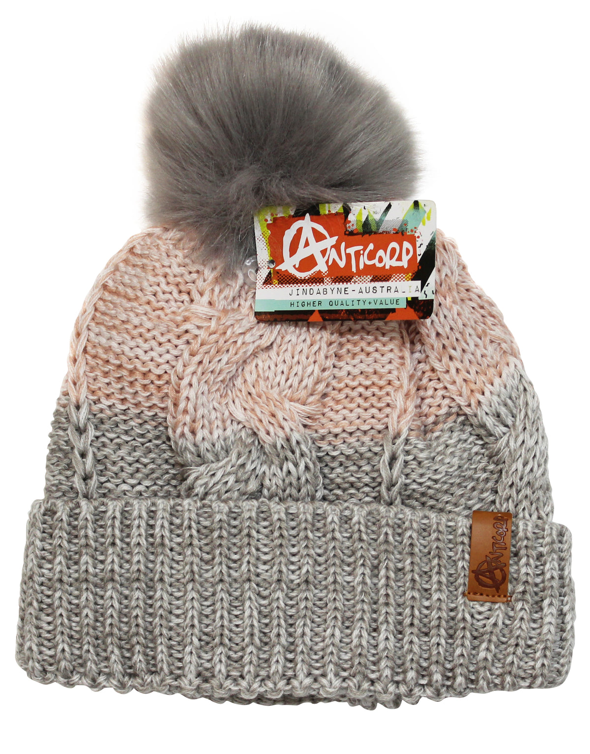 The Anticorp Ladies Freshies Beanie is a knitted hat adorned with a large gray pom-pom on top and showcases a blend of peach, cream, and gray colors. It features a folded brim with a brown leather patch and includes a colorful "Anticorp" label tag. The beanie also has a soft fleece lining for extra warmth.