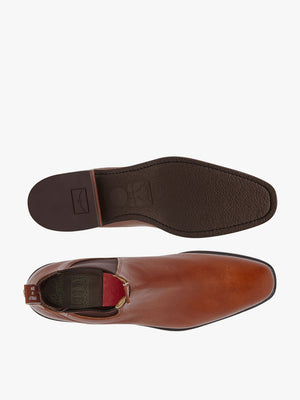 Top and bottom views of the RM Williams Comfort Kangaroo Craftsman Boot, a single brown leather slip-on shoe with a chisel square toe. Crafted from premium kangaroo leather, the sole is dark brown with textured grip and visible branding. The cushioned comfort innersole ensures maximum comfort.