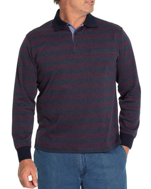 A man is showcasing the Breakaway Lars Micro Prima Polo, a stylish long-sleeve shirt featuring dark blue and maroon stripes, an open pocket on the left chest, and ribbed cuffs. He has paired it with blue jeans. One hand is in his pocket as he stands against a white background.