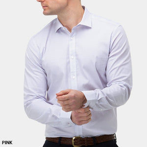 A man in a light pink, long-sleeved Brooksfield Stretch Print Shirt adjusts his left cuff. He is wearing dark pants with a brown woven belt. The background is plain white. The word "PINK" is written in the bottom left corner.