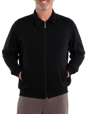 A person wearing a black Breakaway Zed Snowy Mt Fleece Full Zip jacket has their hands in the pockets. They're also in grey cotton polyester pants. Only the torso is visible; their face isn't shown.