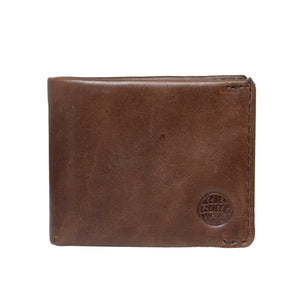 A closed Rip Curl Texas RFID All Day Wallet, made of genuine Texas leather with a slightly worn texture, is shown. The wallet features a circular embossed logo on its bottom right corner, offering both style and RFID protection.