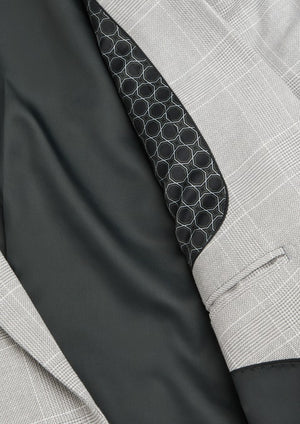 Close-up of the Connor Sorrento Slim Suit Jacket in light grey plaid, partially open to show a dark interior lining with decorative hexagonal trim—an ideal upgrade for any men’s suit collection.