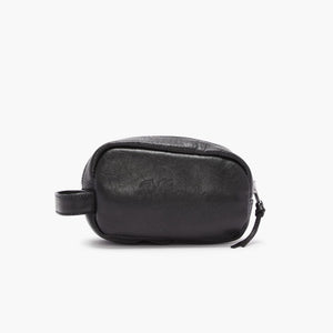 A small black full grain leather bag from RM Williams' Mini Travel Care Kit, featuring a smooth texture with subtle stitching details and a nearly invisible embossed logo on the front. It includes a zipper closure and a short strap on one end for easy carrying.