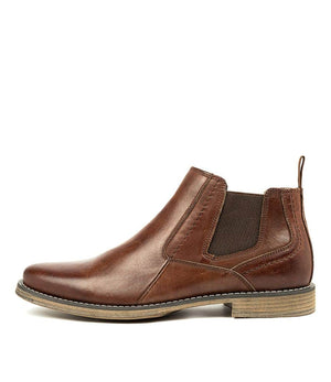 The Colorado Mills Boot is a men's leather Chelsea boot with elastic side panels, a pull-tab at the back, and low heel. It features a beige sole with visible edge stitching and is displayed from a side view on a white background.