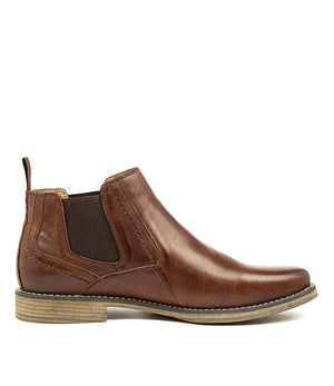 A side view of the Colorado Mills Boot, a men's brown leather Chelsea boot featuring elastic side panels, a wooden sole, a back pull tab, and detailed edge stitching for a timeless style.