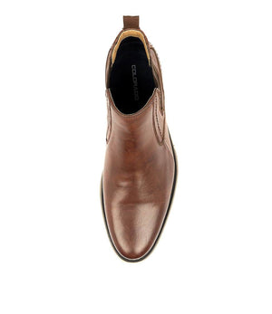 A top view of a single Colorado Mills men's brown leather Chelsea boot displays a pull-up tab and stitching details. The boot features a rounded toe with the brand name "COLORADO" on the insole and a sole with a slight contrast edge.