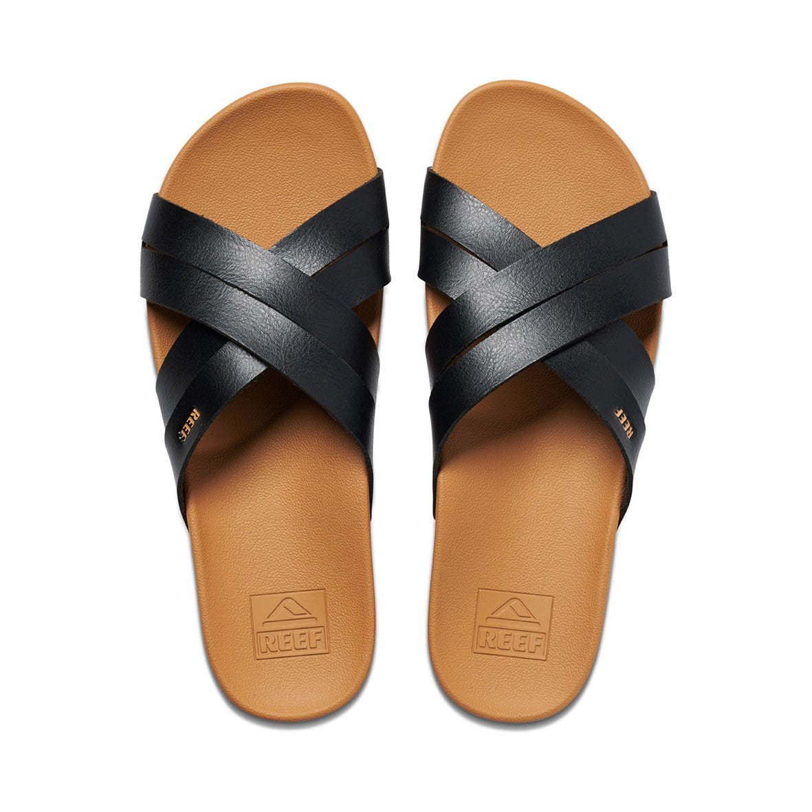 The REEF Cushion Spring Bloom slides feature tan footbeds with black crisscross straps and "REEF" text. They provide supportive arch support for comfortable walking.