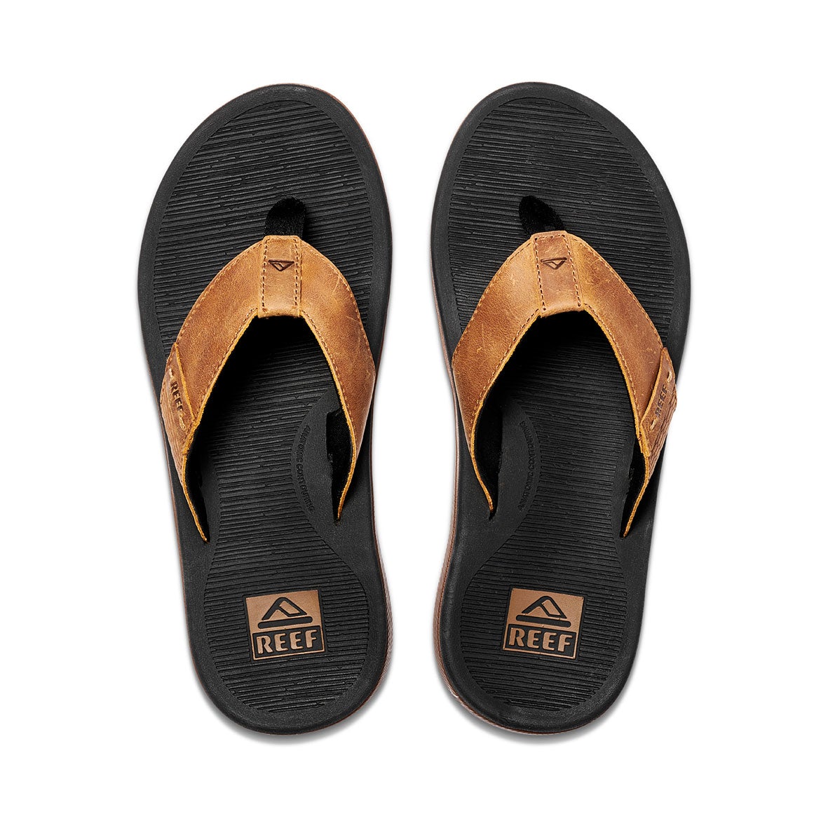 The REEF Santa Ana LE sandals feature black soles with brown leather straps, adorned with the REEF logo. Designed with a toe post and textured footbed for ultimate comfort and arch support, they blend casual style and durability seamlessly. Ideal for any occasion, these water-friendly sandals are perfect for your aquatic adventures.