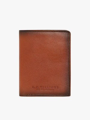 The RM Williams Urban Small Slim Tri-Fold wallet in brown full grain leather features a subtle embossed "R.M. WILLIAMS" logo near the bottom center, shown upright against a white background.