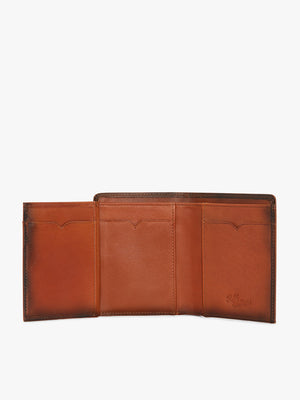The RM Williams Urban Small Slim Tri-Fold is a brown full grain leather wallet with three card slots, subtle stitching, and an embossed logo on the right panel. Shown open, it displays its organized interior.