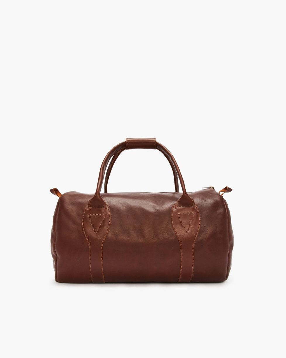The RM Williams Leather Ute Bag is crafted in brown leather with two sturdy handles and visible stitching, displayed on a plain white background.