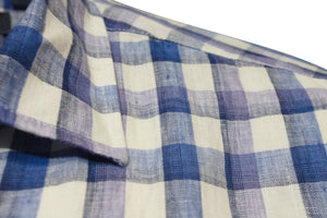 Close-up of the Back Bay Linen Check Short Sleeve Shirt in blue and white plaid, highlighting the fabric's texture. The design features intersecting blue, white, and light purple lines with a slightly visible collar on the left side, adding elegance to its classic style.