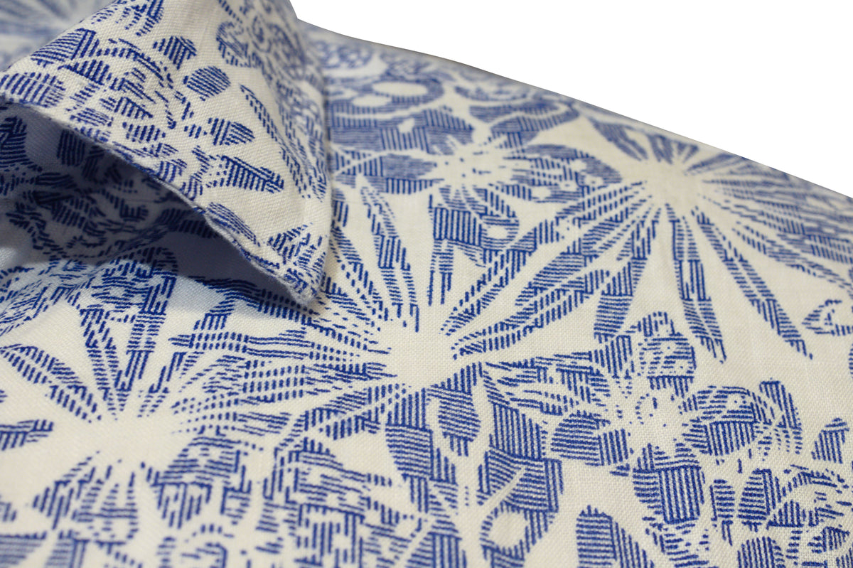 Close-up of the Back Bay Linen Print Short Sleeve Shirt, showcasing a blue and white floral pattern with leaves and flowers. The linen fabric highlights an intricate design, with short sleeves and part of the collar visible.