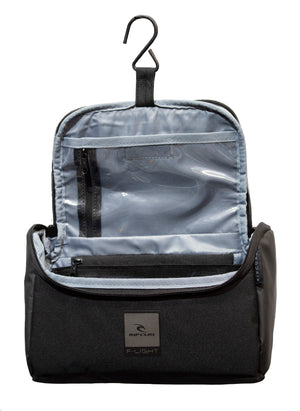 The Rip Curl F-Light Toiletry Midnight bag, made of water-resistant polyester, includes a hook for hanging and has multiple compartments with a clear zippered pocket. The exterior showcases a text logo with a subtle design.