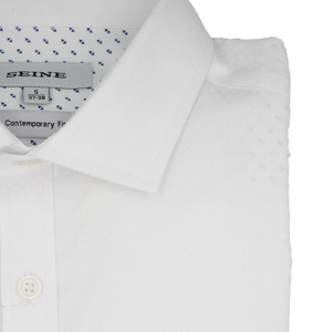 The folded Seine Dress Shirt is a white, contemporary fit with a subtle geometric diamond pattern and buttoned collar. It features small blue accents in the inner lining, a tag labeled "SEINE," and is marked as size small (37-38).